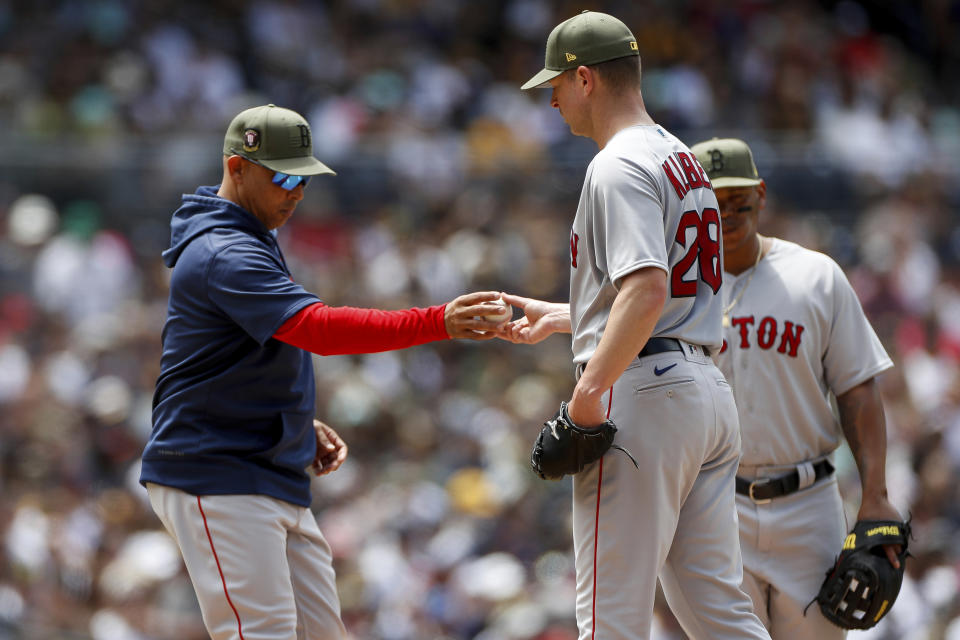 Boston Red Sox manager Alex Cora takes the ball from starting pitcher Corey Kluber during a pitching change in the third inning of a baseball game against the San Diego Padres, Sunday, May 21, 2023, in San Diego. (AP Photo/Brandon Sloter)