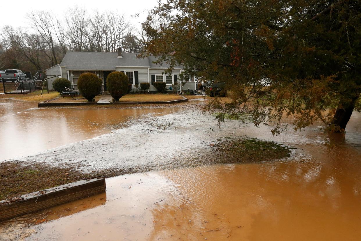 High water from Trail Creek flood the yard outside of a home along East Broad street during storms in Athens, Ga., on Tuesday, Jan. 9, 2024.