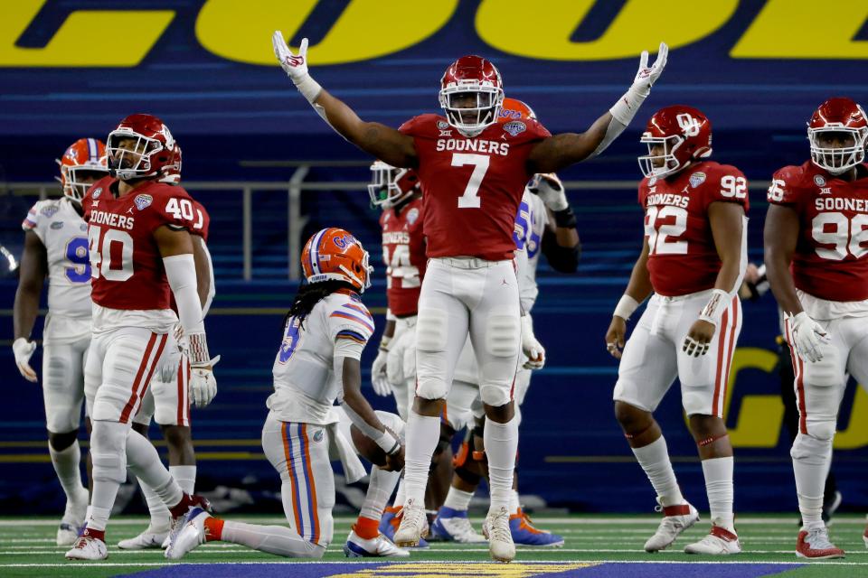 Oklahoma defensive end Ronnie Perkins celebrates after sacking Florida quarterback Emory Jones, on one knee at center left, during the  Cotton Bowl on Dec. 30 in Arlington, Texas.