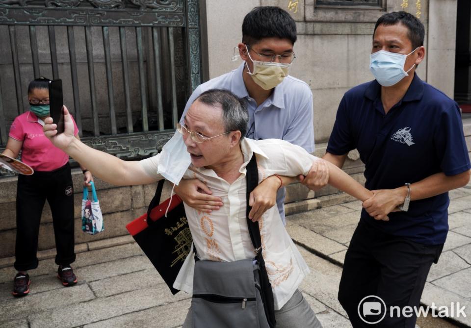 民進黨提名台北市長參選人陳時中到艋舺龍山寺參香時，有市民趁機向他陳情，但被工作人員架開。   圖：張良一/攝（資料照）