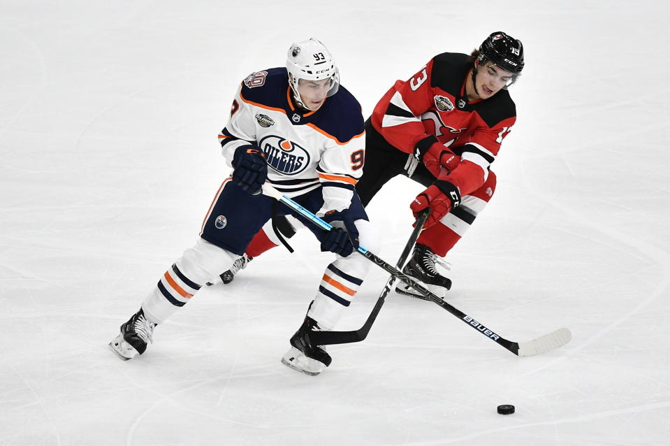 Edmonton Oilers' Ryan Nugent-Hopkins and New Jersey Devils' Nico Hischier vie for the puck, during the season-opening NHL Global Series hockey match between Edmonton Oilers and New Jersey Devils at Scandinavium in Gothenburg, Sweden, Saturday, Oct. 6, 2018, (Bjorn Larsson Rosvall /TT News Agency via AP)