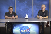 In this frame grab from NASA TV video, astronauts Bob Behnken, left, and Doug Hurley laugh during a news conference, Tuesday, Aug. 4, 2020, in Houston. The two NASA astronauts returned to Earth on Sunday in a dramatic, retro-style splashdown carried out by Elon Musk's SpaceX company. (NASA TV via AP)