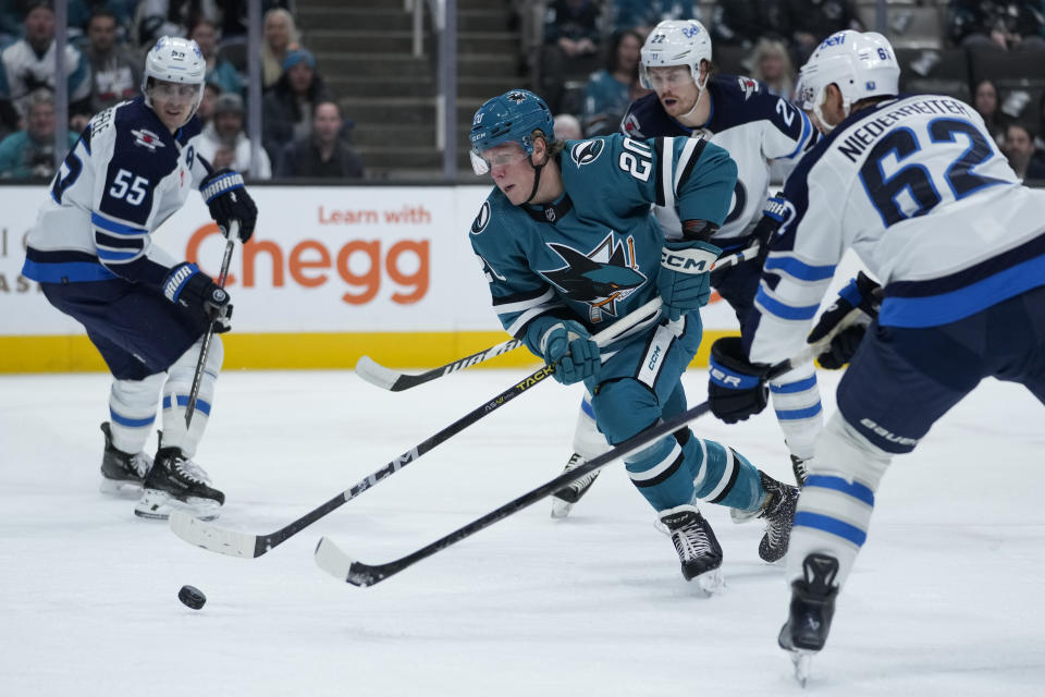 San Jose Sharks left wing Fabian Zetterlund moves the puck between Winnipeg Jets players during the first period of an NHL hockey game, Tuesday, Dec. 12, 2023, in San Jose, Calif. (AP Photo/Godofredo A. Vásquez)