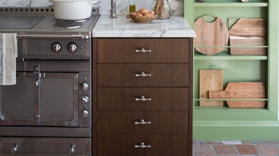 green kitchen with wood cabinets and wood cutting board decor