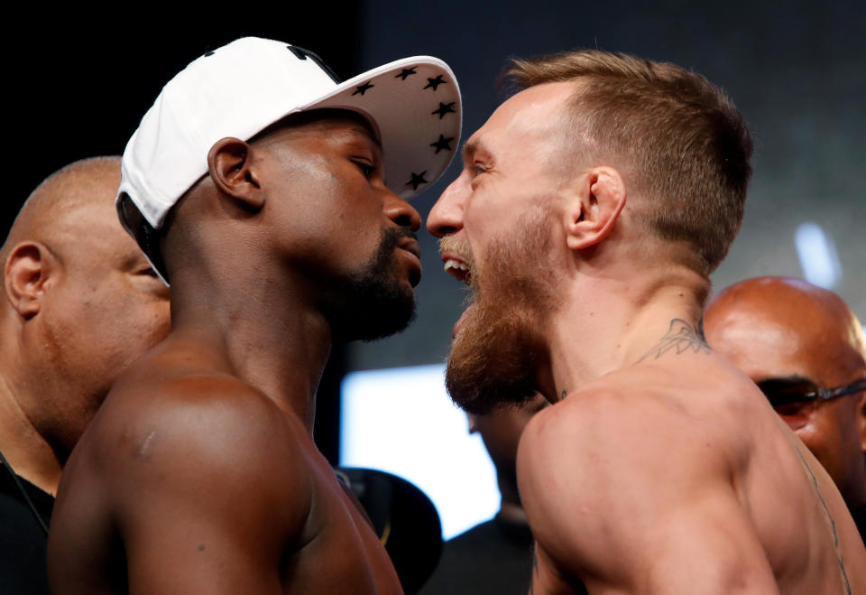 Undefeated boxer Floyd Mayweather Jr. (L) of the U.S. and UFC lightweight champion Conor McGregor of Ireland face off during their official weigh-in at T-Mobile Arena in Las Vegas, Nevada, U.S. on August 25, 2017. (Reuters)