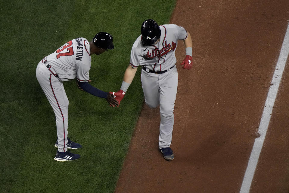 Atlanta Braves' Sean Murphy celebrates with third base coach Ron Washington (37) after hitting a solo home run during the fifth inning of a baseball game against the Kansas City Royals Friday, April 14, 2023, in Kansas City, Mo. (AP Photo/Charlie Riedel)