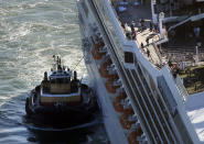 In this aerial photo, the cruise ship Carnival Triumph is towed into Mobile Bay, Ala. Thursday, Feb. 14, 2013. The ship with more than 4,200 passengers and crew members has been idled for nearly a week in the Gulf of Mexico following an engine room fire. (AP Photo/Gerald Herbert)