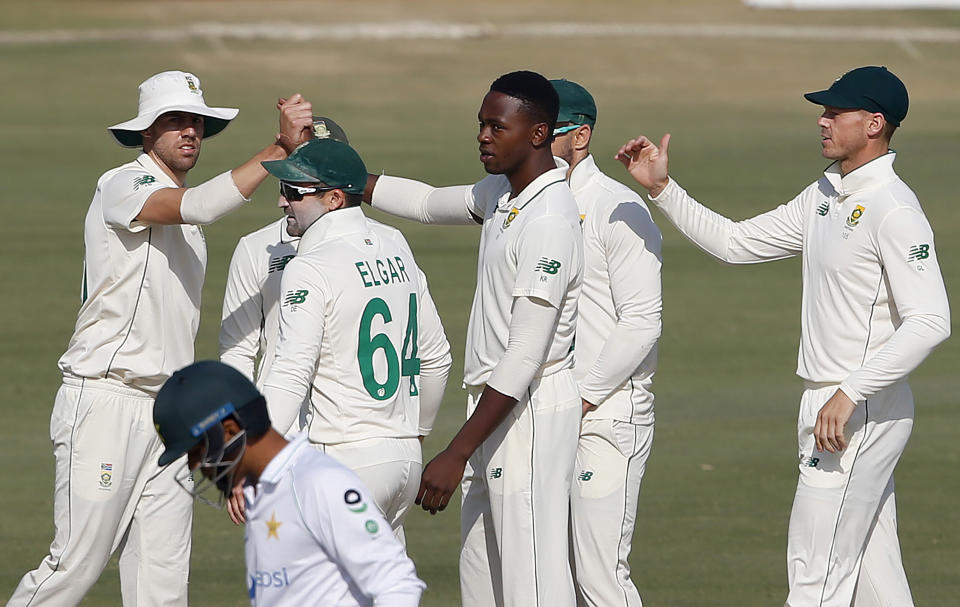 South Africa's Kagiso Rabada, center without cap, celebrates with teammates after taking the wicket of Pakistan's Hasan Ali during the third day of the first cricket test match between Pakistan and South Africa at the National Stadium, in Karachi, Pakistan, Thursday, Jan. 28, 2021. (AP Photo/Anjum Naveed)