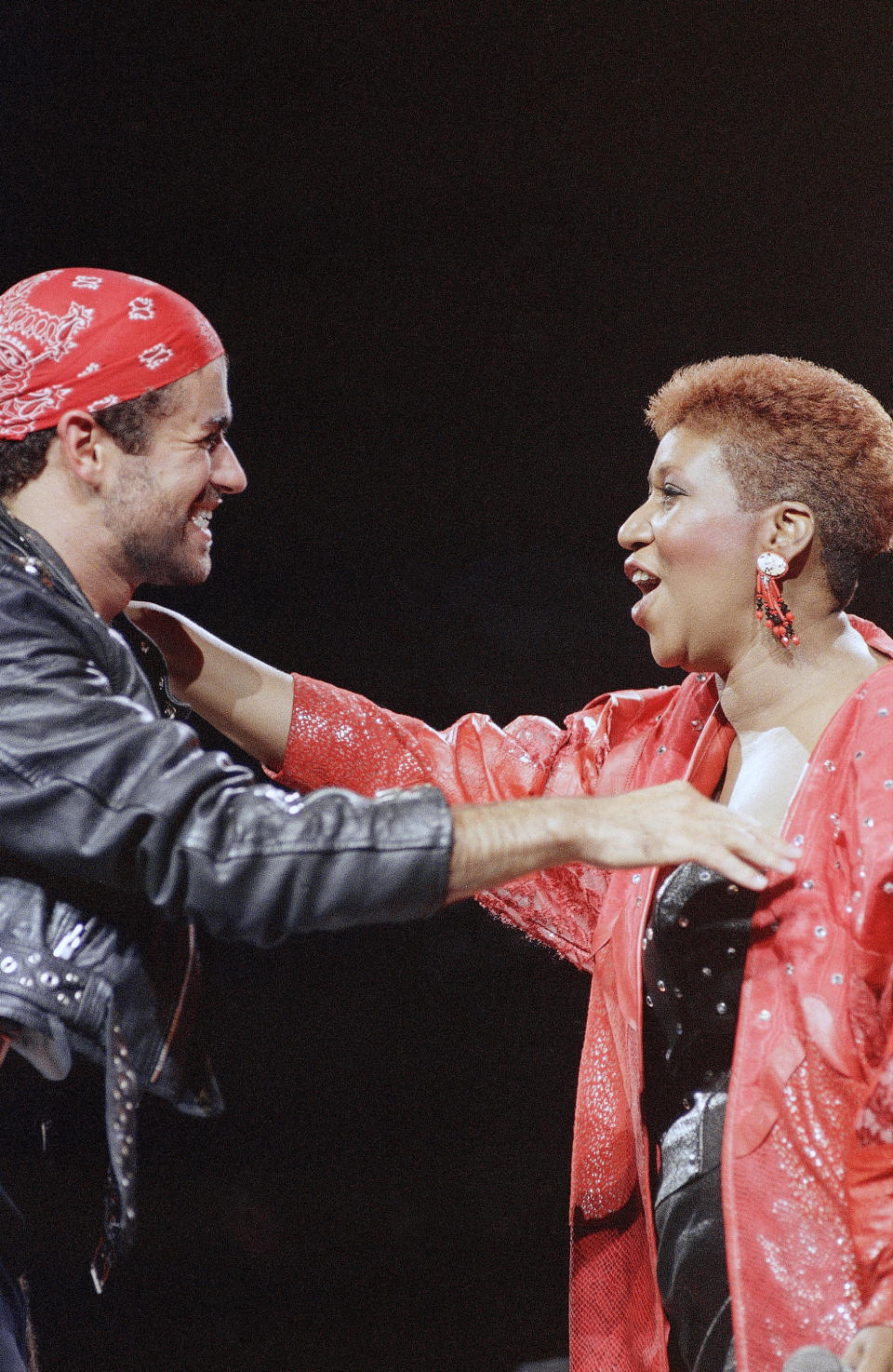 <p>Aretha Franklin mit George Michael auf der Bühne in Detroit während seiner Faith World Tour. Sie trägt eine rote Nietenlederjacke und kurze, rotbraune Haare. Das Duo sang den Grammy-Hit „I Knew You Were Waiting“. (AP Foto/Rob Kozloff) </p>