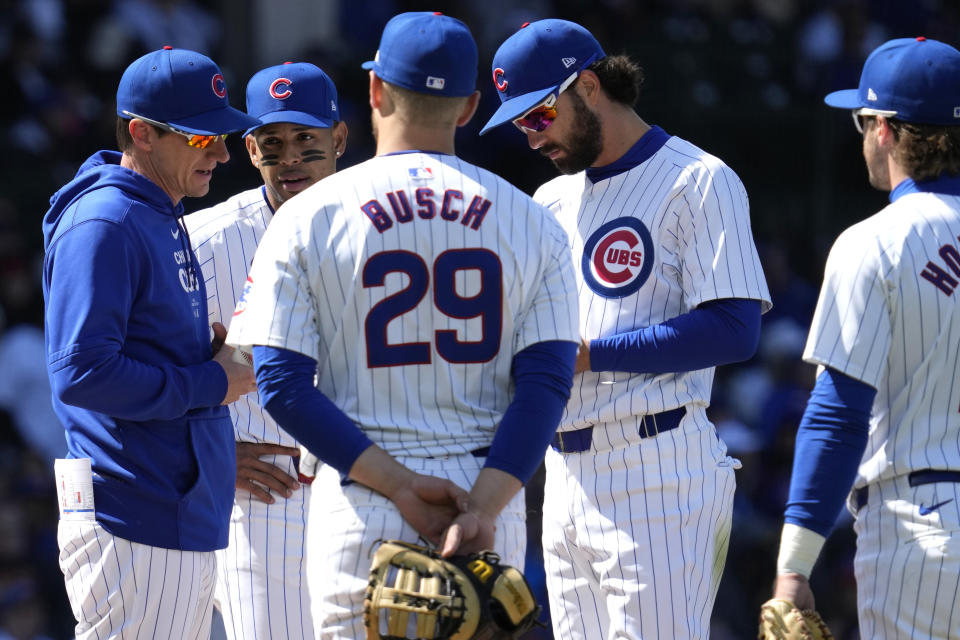 Chicago Cubs manager Craig Counsell, left, talks to players during the seventh inning of a baseball game against the Miami Marlins in Chicago, Sunday, April 21, 2024. (AP Photo/Nam Y. Huh)