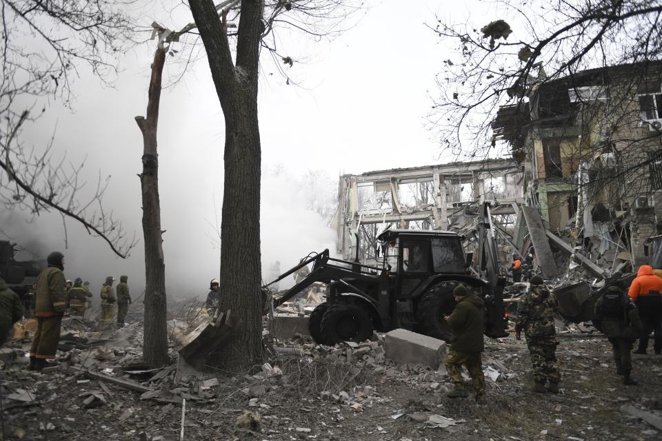 Donetsk's emergency employees work at a site of a shopping center destroyed after what Russian officials in Donetsk said it was a shelling by Ukrainian forces, in Donetsk, in Russian-controlled Donetsk region, eastern Ukraine, Monday, Jan. 16, 2023. (AP Photo)