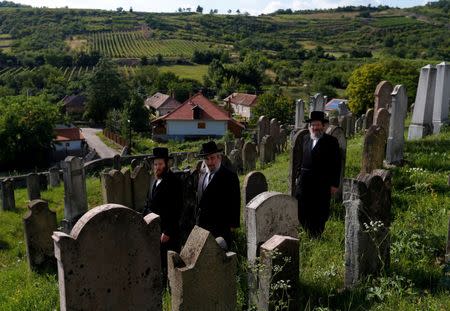 Three rabbis, the sons and grandson of a leading Hasidic rabbi Eliezer Ehrenreich walk in the cemetery in the village of Mad, Hungary, July 21, 2016. Picture taken July 21, 2016. REUTERS/Laszlo Balogh