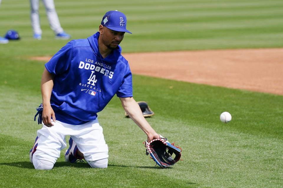 Los Angeles Dodgers' Mookie Betts warms up during a spring training baseball workout Sunday, March 13, 2022, in Phoenix. (AP Photo/Ross D. Franklin)