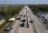 This aerial photo provided by the Florida Keys News Bureau, shows a checkpoint at the top of the Florida Keys Overseas Highway, Friday, March 27, 2020, near Key Largo, Fla. The Keys have been temporarily closed to visitors and non-residents since March 22, because of the coronavirus crisis. (Andy Newman/Florida Keys News Bureau via AP)