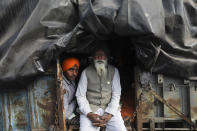 FILE - In this Friday, Jan. 1, 2021, file photo, an elderly farmer sits with his grandson in the back of their tractor trailer as they join a protest blocking a highway at the Delhi- Haryana border at the outskirts of New Delhi, India. Most of the protesters are farmers from northern Punjab and Haryana states, the two biggest agricultural producers. Farmers form the most influential voting bloc in India — and are often romanticized as the heart and soul of the nation. (AP Photo/Manish Swarup, File)