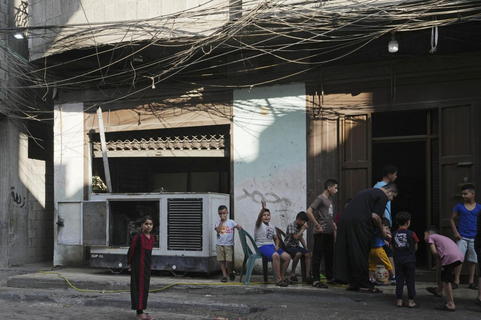 Children hang out near an electricity generator under electricity distribution wires in the Shati refugee camp, Gaza City, July 8, 2022. Private generators are ubiquitous in parts of the Middle East, spewing hazardous fumes into homes and business across the country, almost 24 hours a day. As the world looks for renewable energy to tackle climate change, Lebanon, Iraq, Gaza and elsewhere rely on diesel-powered private generators just to keep the lights on. The reason is state failure: In multiple countries, governments can’t maintain a functioning central power network, whether because of war, conflict or mismanagement and corruption. (AP Photo/Adel Hana)