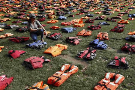 A woman looks at a display of lifejackets worn by refugees during their crossing from Turkey to the Greek island of Chois, Parliament Square in central London, Britain September 19, 2016. REUTERS/Stefan Wermuth