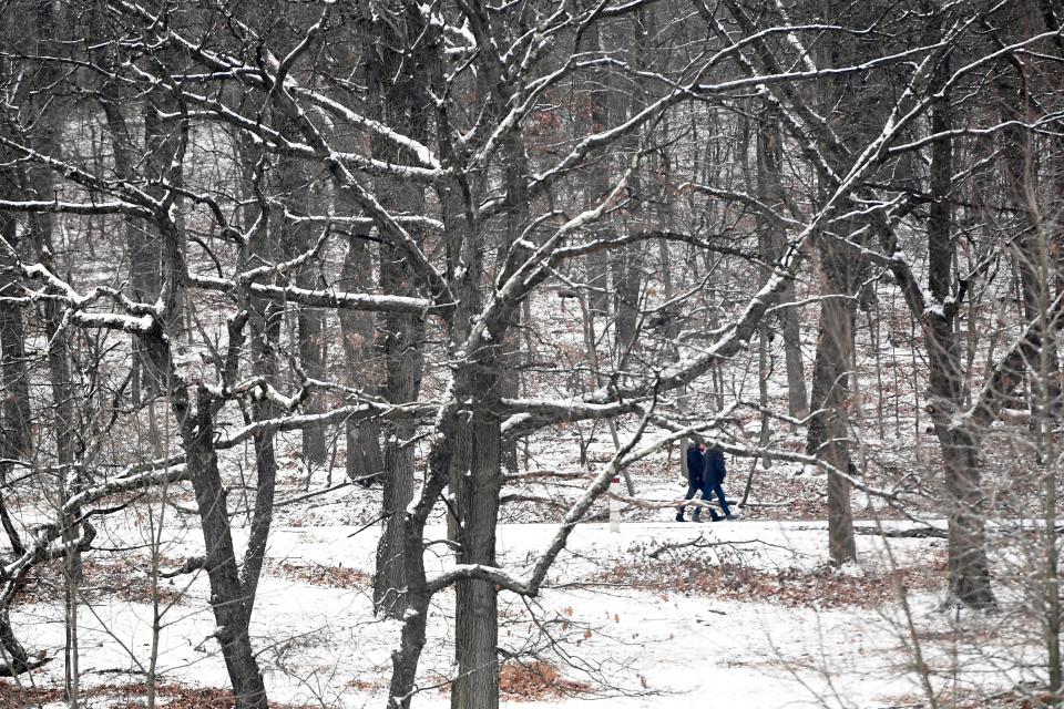 People walk along a snowy trail at Garret Mountain Reservation on Tuesday, Jan. 29, 2019, in Woodland Park. 