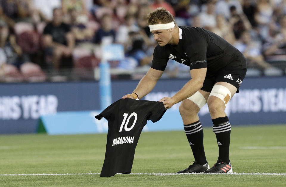 New Zealand captain Sam Cane lays All Black number 10 jersey on the pitch in memory of late Argentina soccer star Diego Maradona prior to the start Tri-Nations rugby test between Argentina and the All Blacks in Newcastle, Australia, Saturday, Nov. 28, 2020. (AP Photo/Rick Rycroft)