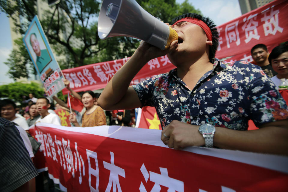 Protesters shout anti-Japan slogans near the Japanese Consulate General Tuesday, Sept. 18, 2012, in Shanghai, China. The 81st anniversary of a Japanese invasion brought a fresh wave of anti-Japan demonstrations in China on Tuesday, with thousands of protesters venting anger over the colonial past and a current dispute involving contested islands in the East China Sea.  (AP Photo/Eugene Hoshiko)