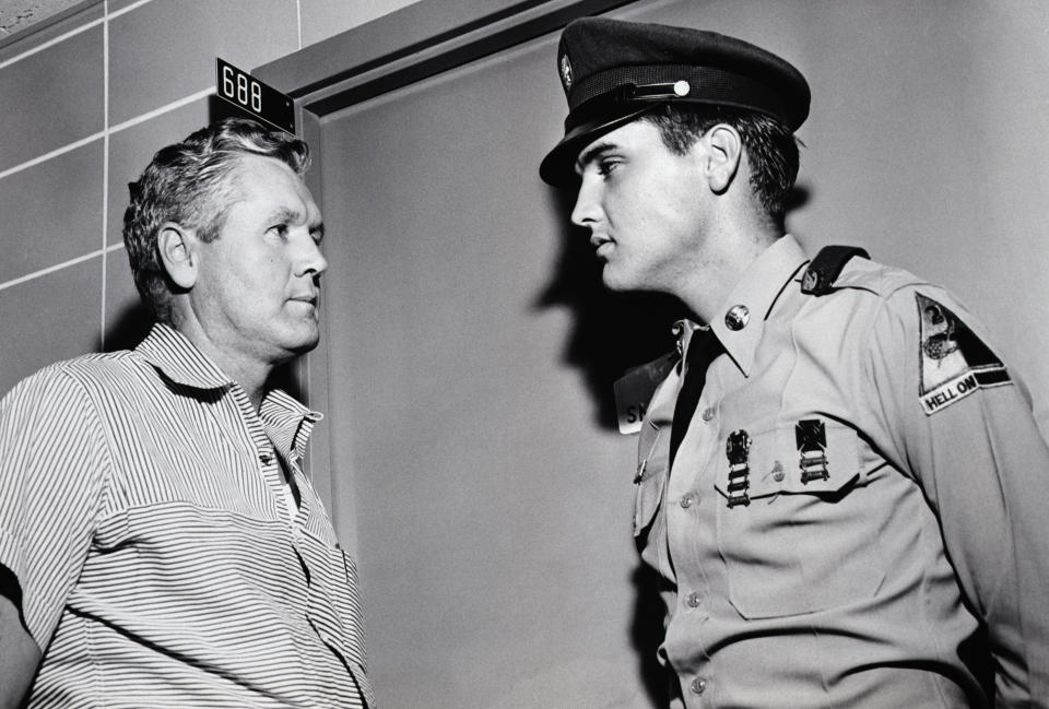 (Original Caption) 8/12/1958-Memphis, TN: Pvt. Elvis Presley and his father, Vernon Presley discuss the illness of Presley's mother outside her hospital room. Mrs. Presley is hospitalized with a liver ailment described as 