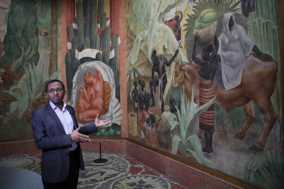 FILE - Pap Ndiaye, a Black French scholar and expert on the U.S. civil rights movement gestures inside France's National Museum of the History of Immigration, in Paris, Thursday, March 11, 2021. Pap Ndiaye, was named Friday May 20, 2022 education minister. Ndiaye was previously in charge of France's state-run immigration museum. In an Associated Press interview last year, Ndiaye said France has to fight racial justice by confronting its often-violent colonial past, noting that "the French are highly reluctant to look at the dark dimensions of their own history." (AP Photo/Francois Mori, File)