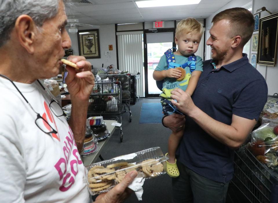 Ukrainian refugee Ostap Losyk smiles at his son, Zachar, as the boy shares some cookies with Marvin Miller, president of the Jewish Federation of Volusia and Flagler Counties. A volunteer in the fight against the Russian invasion, Ostap Losky was reunited with his family this week in Volusia County.