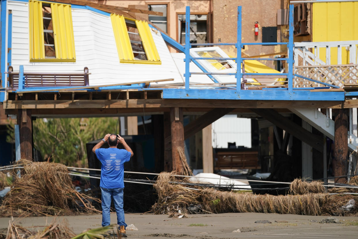 A man documents storm damage to a house after Hurricane Ida