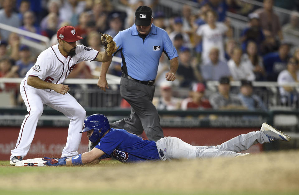 Chicago Cubs' Kris Bryant, bottom, slides safely into third on a single by Albert Almora Jr., next to Washington Nationals third baseman Anthony Rendon, left, during the eighth inning of a baseball game Thursday, Sept. 6, 2018, in Washington. The Cubs won 6-4 in 10 innings. (AP Photo/Nick Wass)