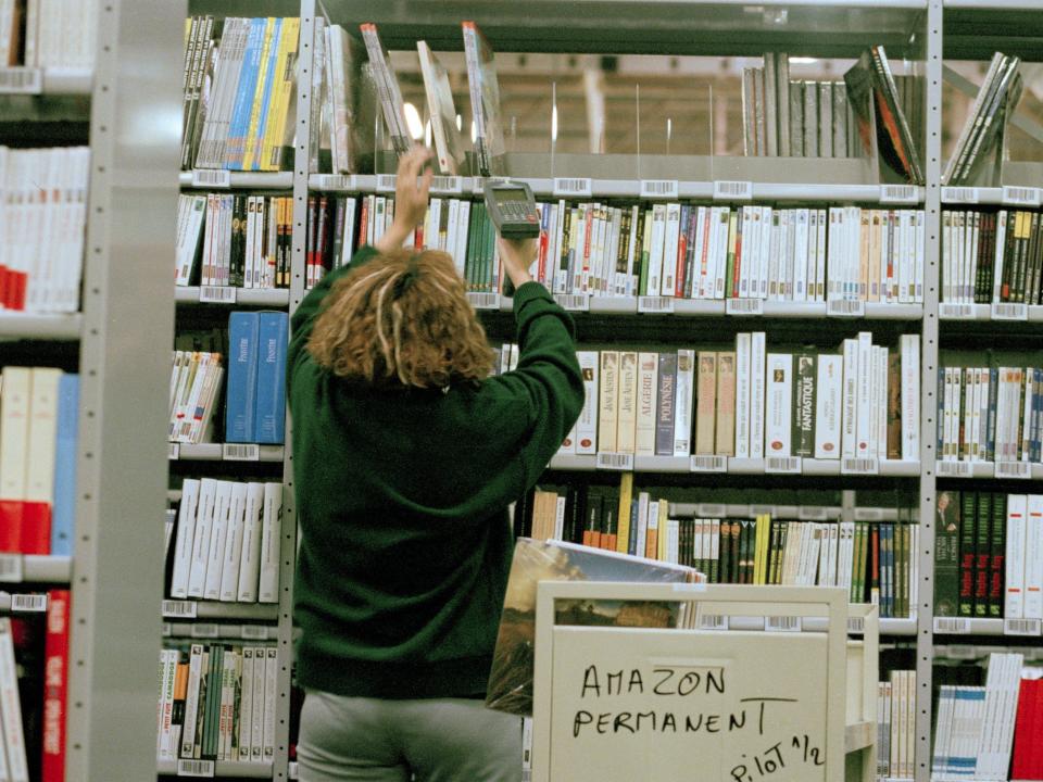 Amazon employee scans books at Amazon warehouse