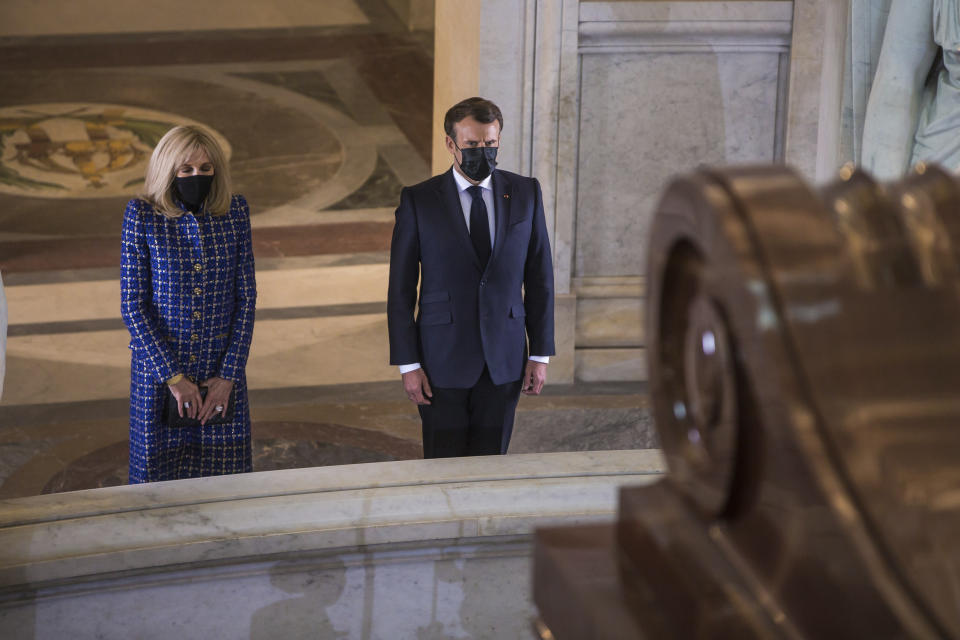 El presidente francés Emmanuel Macron y su esposa Brigitte Macron montan guardia el miércoles 5 de mayo de 2021 frente a la tumba de Napoleón Bonaparte durante una ceremonia para conmemorar el bicentenario de su muerte, en el monumento de Los Inválidos, en París. (Christophe Petit Tesson/Pool vía AP)