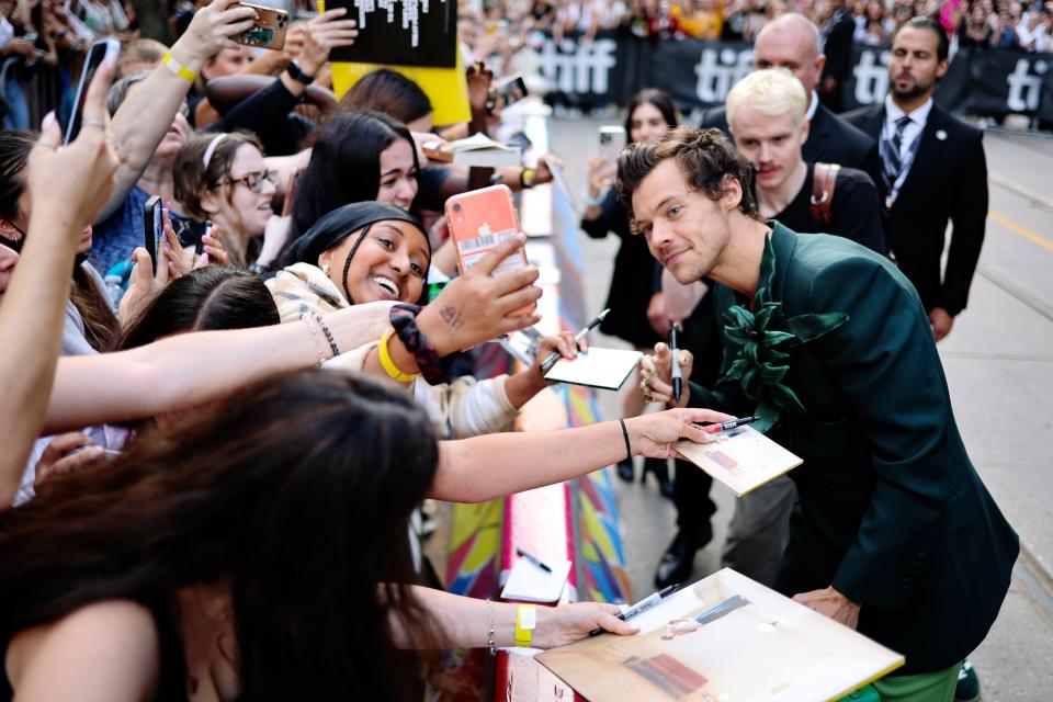 Harry Styles greets excited fans at the "My Policeman" premiere during the 2022 Toronto International Film Festival.