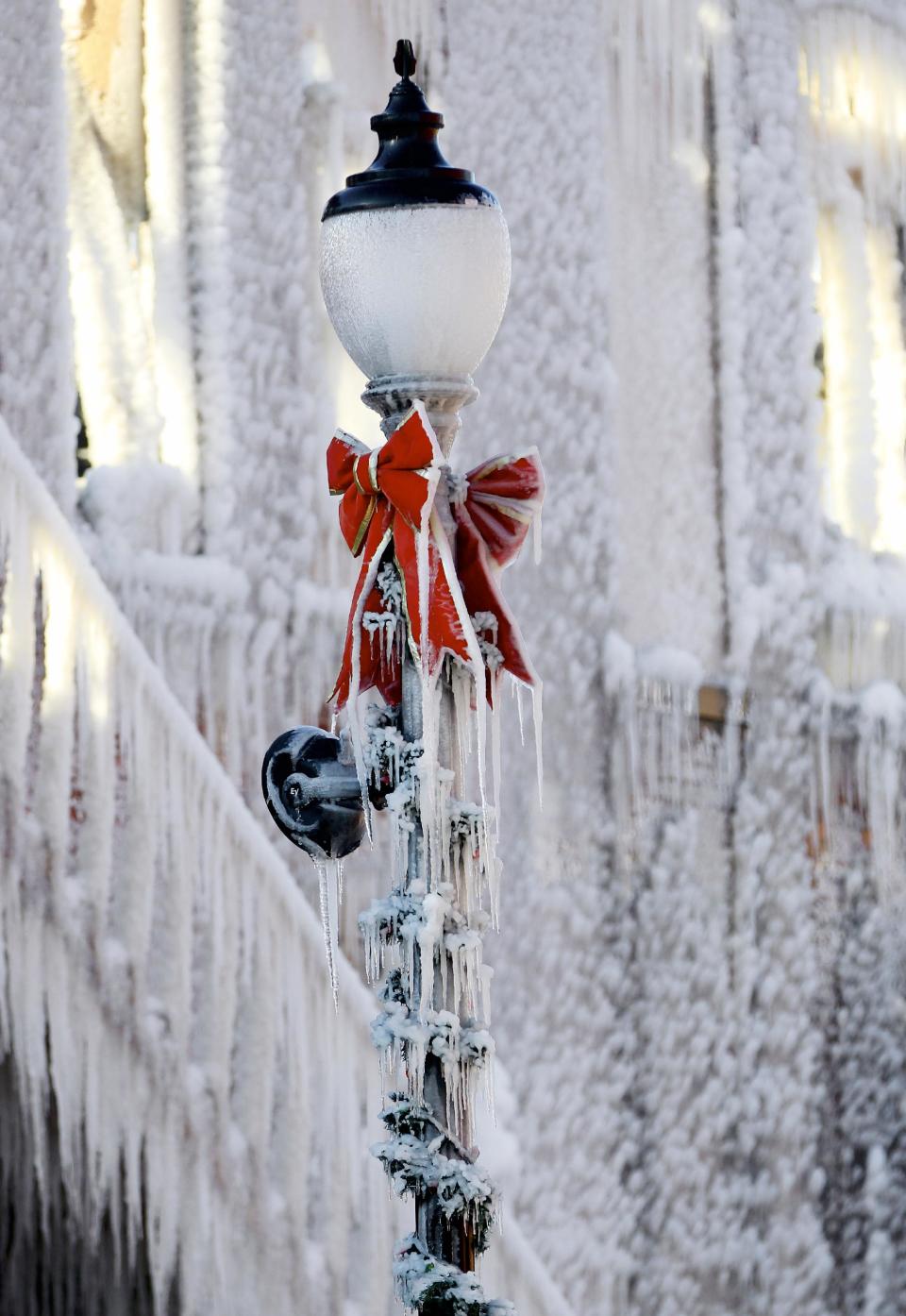 A street light is covered with icicles near a building which caught on fire in Plattsmouth, Neb., Friday, Jan. 3, 2014, and the water sprayed on it by fire fighters froze. Much of the American northeast and the midwest are suffering from sub-freezing temperatures. (AP Photo/Nati Harnik)