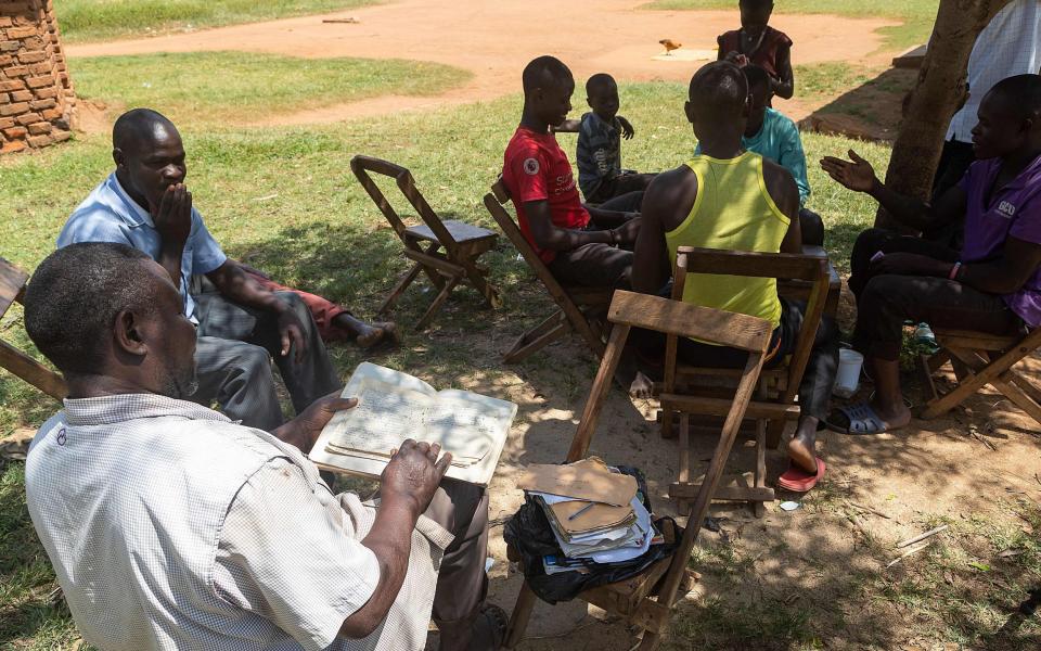 Musa Hasahya Kasera relies on notebooks to help identify his many children - Badru Katumba/AFP via Getty Images