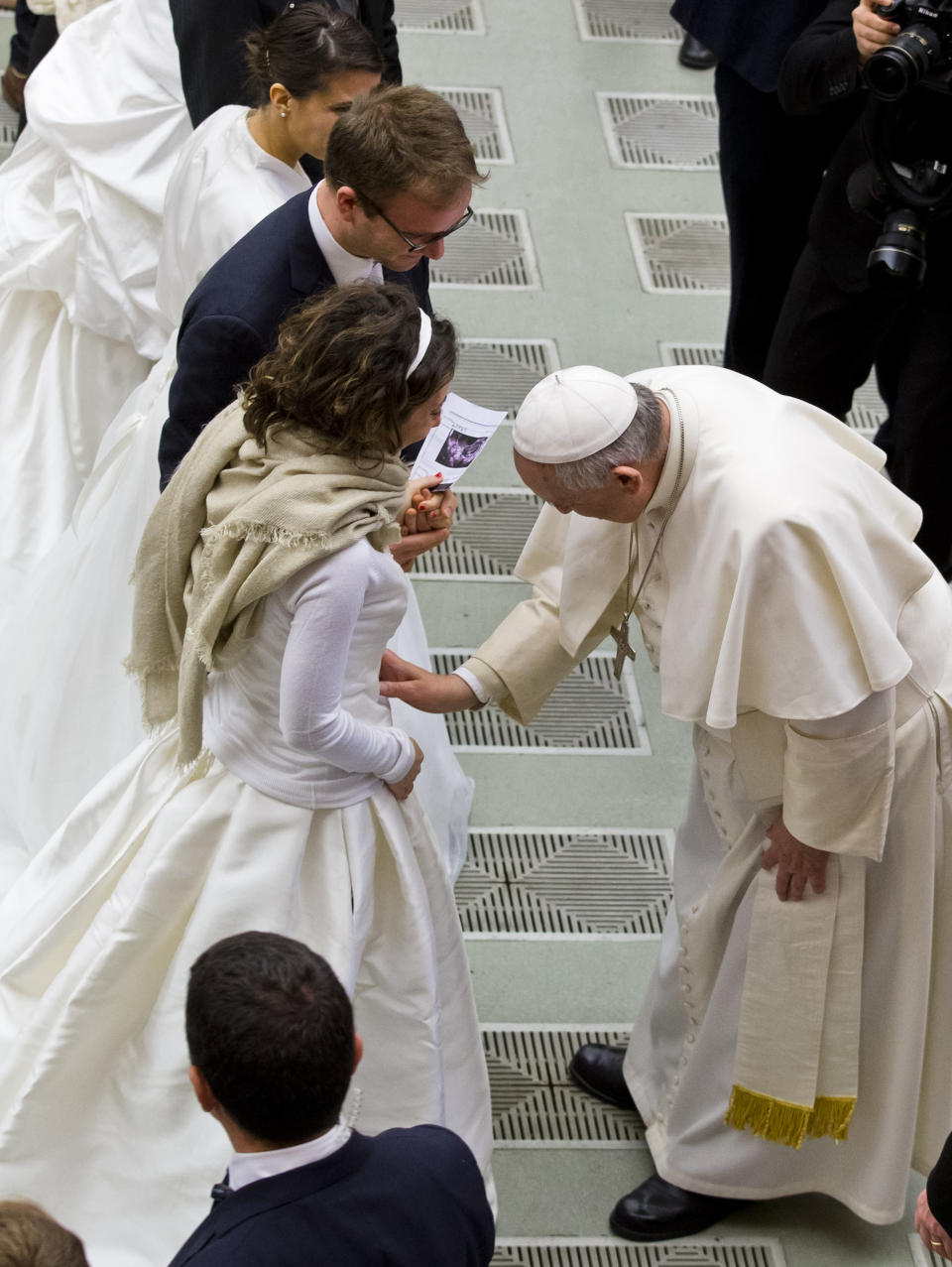 FILE - Pope Francis, right, blesses a newly wed couple during his weekly general audience in the Pope Paul VI hall, at the Vatican, on Feb. 4, 2015. Pope Francis has formally approved allowing priests to bless same-sex couples, with a new document released Monday Dec. 18, 2023 explaining a radical change in Vatican policy by insisting that people seeking God’s love and mercy shouldn’t be subject to “an exhaustive moral analysis” to receive it. (AP Photo/Andrew Medichini, File)