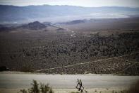 Carlos Alberto Gomes De Sa of Portugal (L) walks with his pace setter on his way to winning the Badwater Ultramarathon at the foot of Mount Whitney, California in this July 16, 2013 file photo. An ultramarathon involves a combination of running and walking further than the traditional marathon of 26.2 miles (42.2 kilometres). Though most ultras cover distances of either 50 or 100 miles, many are much longer. For the ultramarathoner, it is all about running for joy, setting personal goals and trying to overcome every obstacle faced. To match ATHLETICS-ULTRAMARATHONS/ REUTERS/Lucy Nicholson/Files (UNITED STATES - Tags: SPORT ATHLETICS)