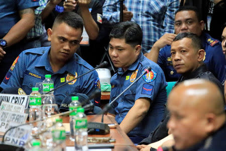 Philippines National Police officers Jeremias Pereda, Jerwin Cruz and Arnel Oares appear during a hearing on the killing of 17-year-old high school student Kian Delos Santos in a recent police raid, at the Senate headquarters in Pasay city, metro Manila, Philippines August 24, 2017. REUTERS/Romeo Ranoco