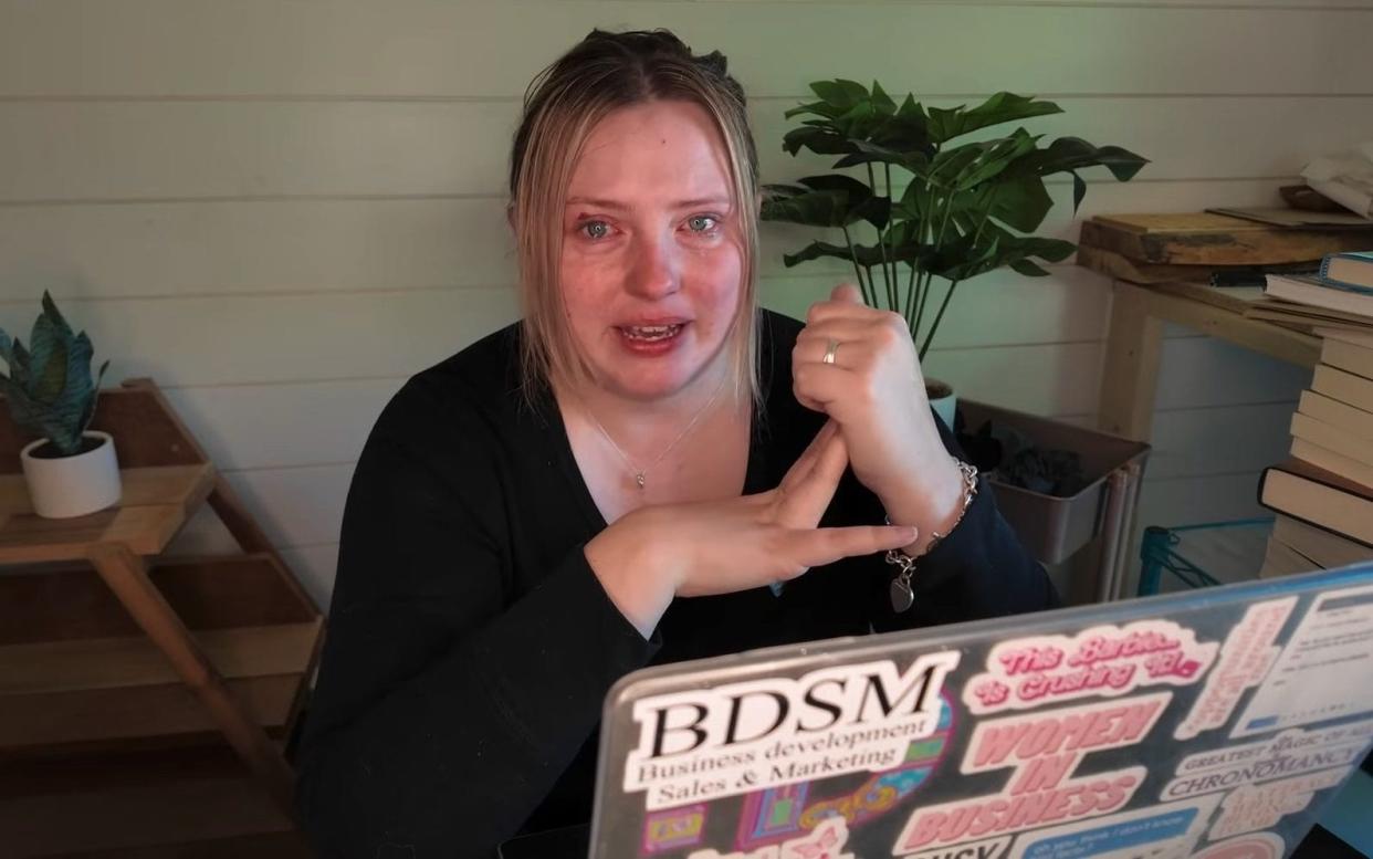 A woman crying behind a laptop