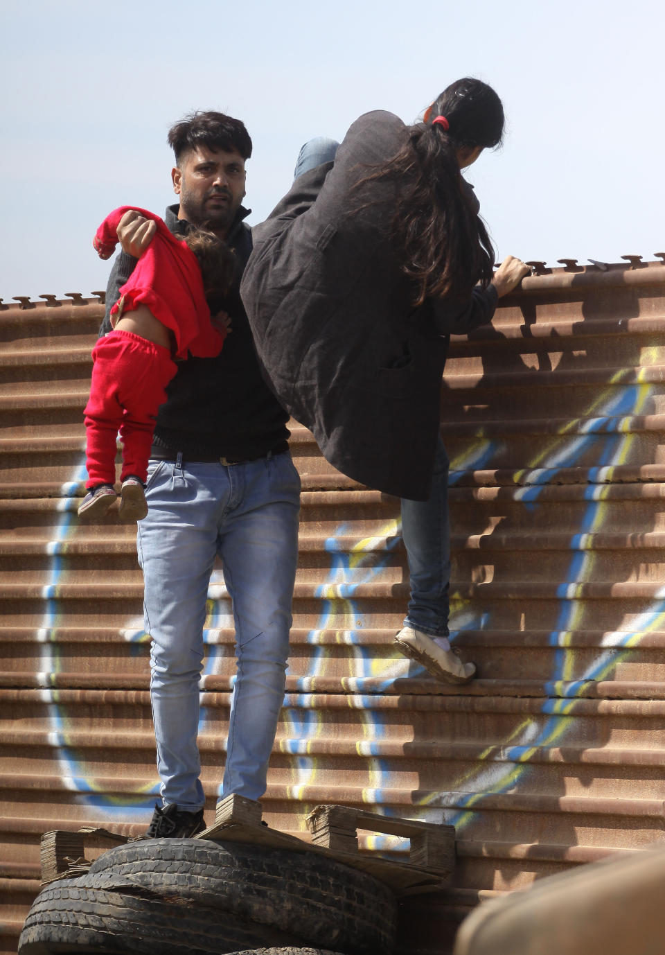 (FOTOS) La familia migrante que cruzó ilegalmente la frontera frente a los muros de Trump