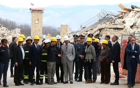 Britain's Prince Charles listens to an Italy's Civil Protection agency member during his visit to the town of Amatrice, which was levelled after an earthquake last year, in central Italy April 2, 2017. REUTERS/Alessandro Bianchi