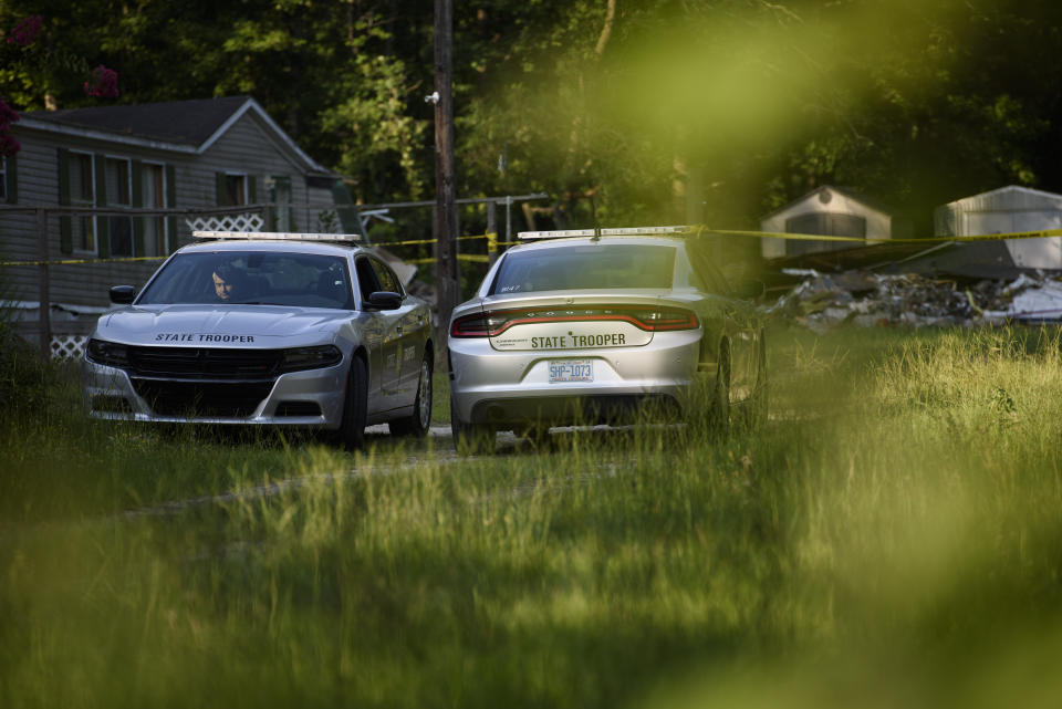 Police officers wait in their vehicles outside a home where a small plane had crashed into the home late Thursday evening in Hope Mills, N.C. on Friday, June 28, 2019. A single-engine plane crashed into the home, killing the pilot and someone inside the house, authorities said. Another person in the house was seriously hurt. (Melissa Sue Gerrits /The Fayetteville Observer via AP)