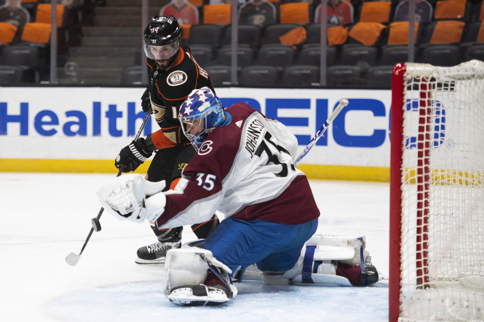 Anaheim Ducks center Adam Henrique, top, tries to deflect the puck in front of Colorado Avalanche goaltender Jonas Johansson in the second period of an NHL hockey game in Anaheim, Calif., Sunday, April 11, 2021. (AP Photo/Kyusung Gong)