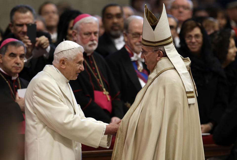 FILE - Pope Emeritus Benedict XVI, left, greets Pope Francis in St. Peter's Basilica at the Vatican during a consistory, on Feb. 14, 2015. Pope Benedict XVI’s 2013 resignation sparked calls for rules and regulations for future retired popes to avoid the kind of confusion that ensued. Benedict, the German theologian who will be remembered as the first pope in 600 years to resign, has died, the Vatican announced Saturday Dec. 31, 2022. He was 95. (AP Photo/Andrew Medichini, File)