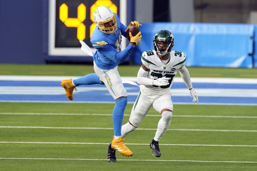 Los Angeles Chargers wide receiver Keenan Allen, left, catches the ball in front of New York Jets.