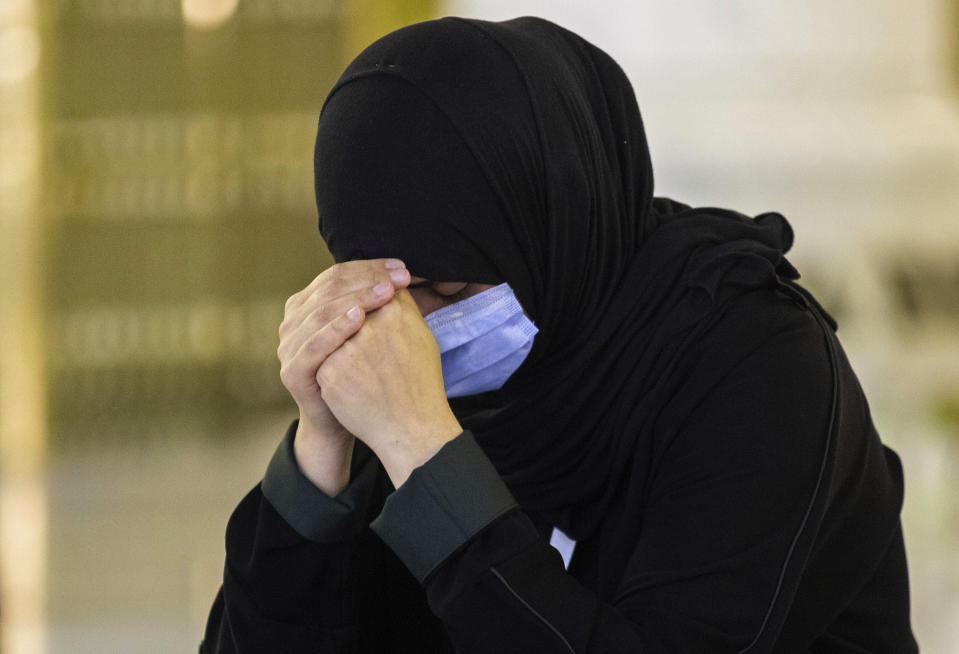 In this photo released by the Saudi Media Ministry, a woman, among a limited numbers of pilgrims, prays in the first rituals of the hajj, while keeping social distancing to limit exposure and the potential transmission of the coronavirus, at the Grand Mosque in the Muslim holy city of Mecca, Saudi Arabia, Wednesday, July 29, 2020. A unique and scaled-down hajj started on Wednesday. (Saudi Media Ministry via AP)