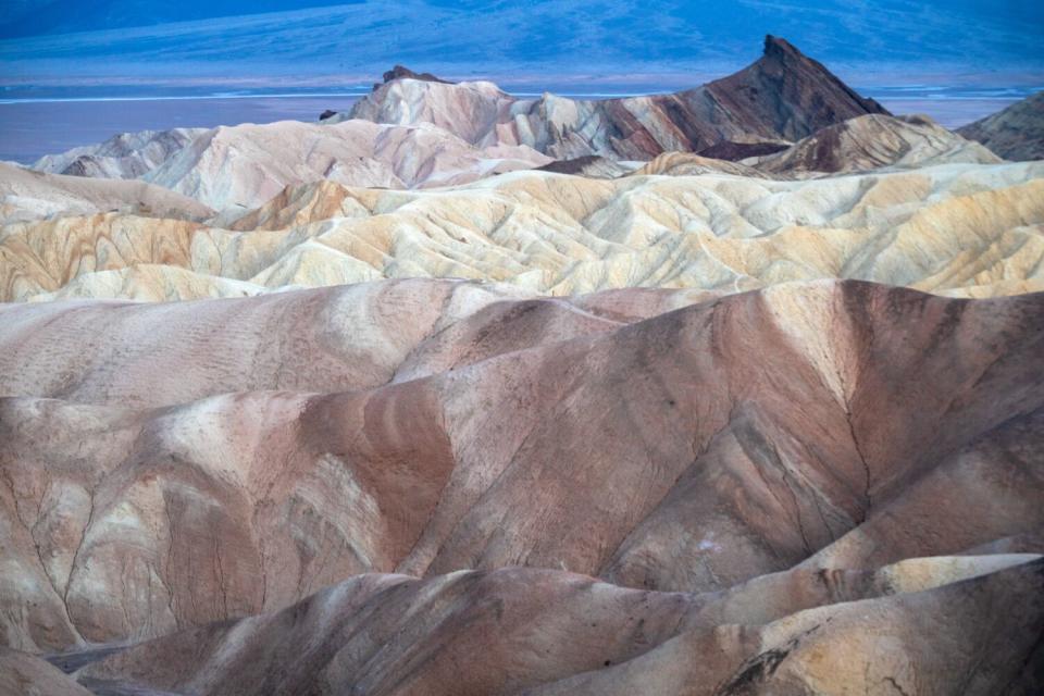 A horizontal frame of cascading rows of arid mountains without vegetation.