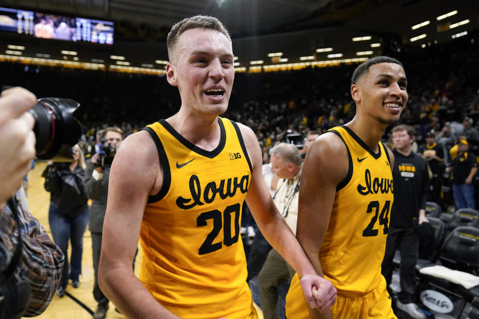 Iowa forward Payton Sandfort (20) walks off the court with teammate Kris Murray (24) after an NCAA college basketball game against Michigan, Thursday, Jan. 12, 2023, in Iowa City, Iowa. Iowa won 93-84 in overtime. (AP Photo/Charlie Neibergall)
