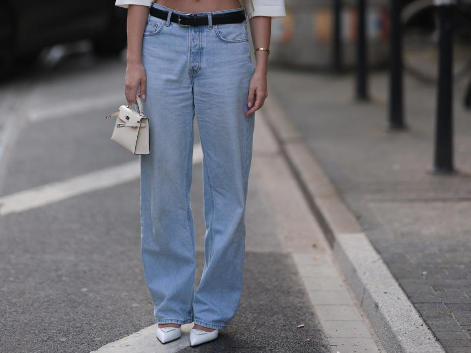 Baggy jeans with a black belt on a model.