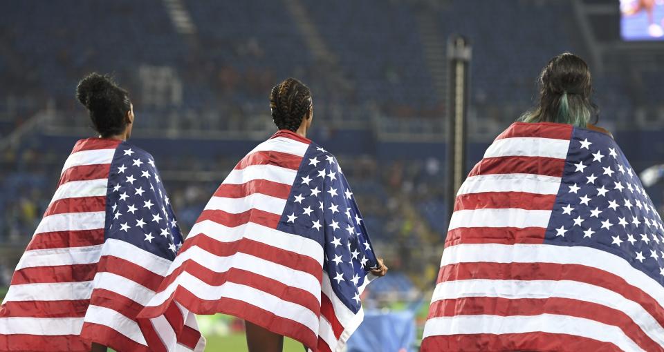 Kristi Castlin, Brianna Rollins and Nia Ali celebrate with flags. (REUTERS)