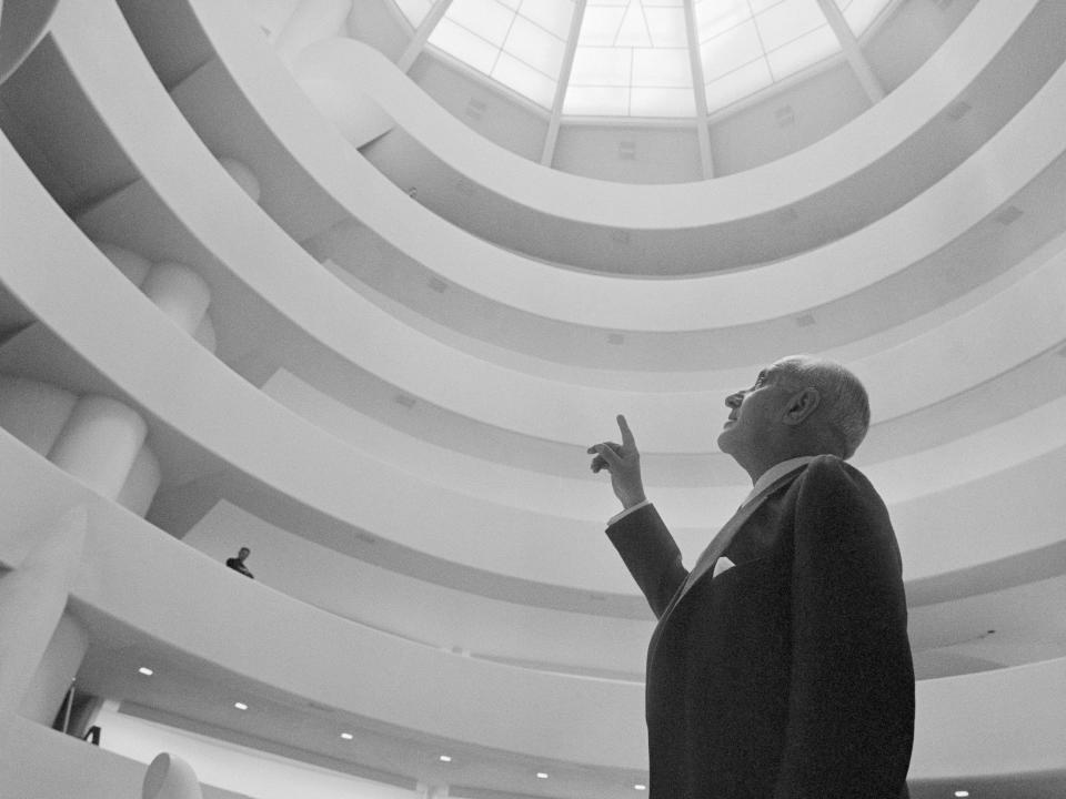 The Guggenheim Museum at 1071 5th Avenue is shown with Harry F. Guggenheim, as he points to a glass dome designed by Frank Lloyd Wright.